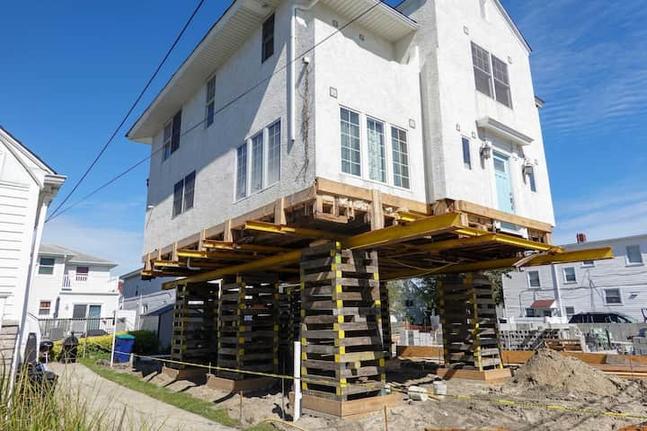 A team of professionals using specialized equipment to raise a house in Durham, preparing it for elevation and renovation